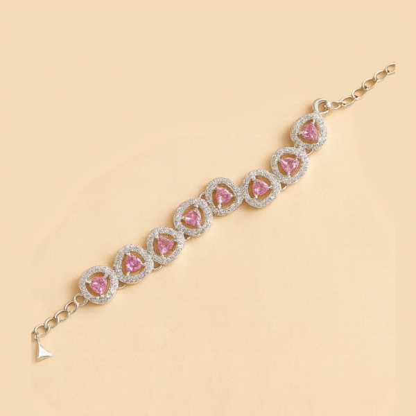 Silver bracelet featuring pink heart-shaped stones surrounded by American Diamonds in a circular halo design.