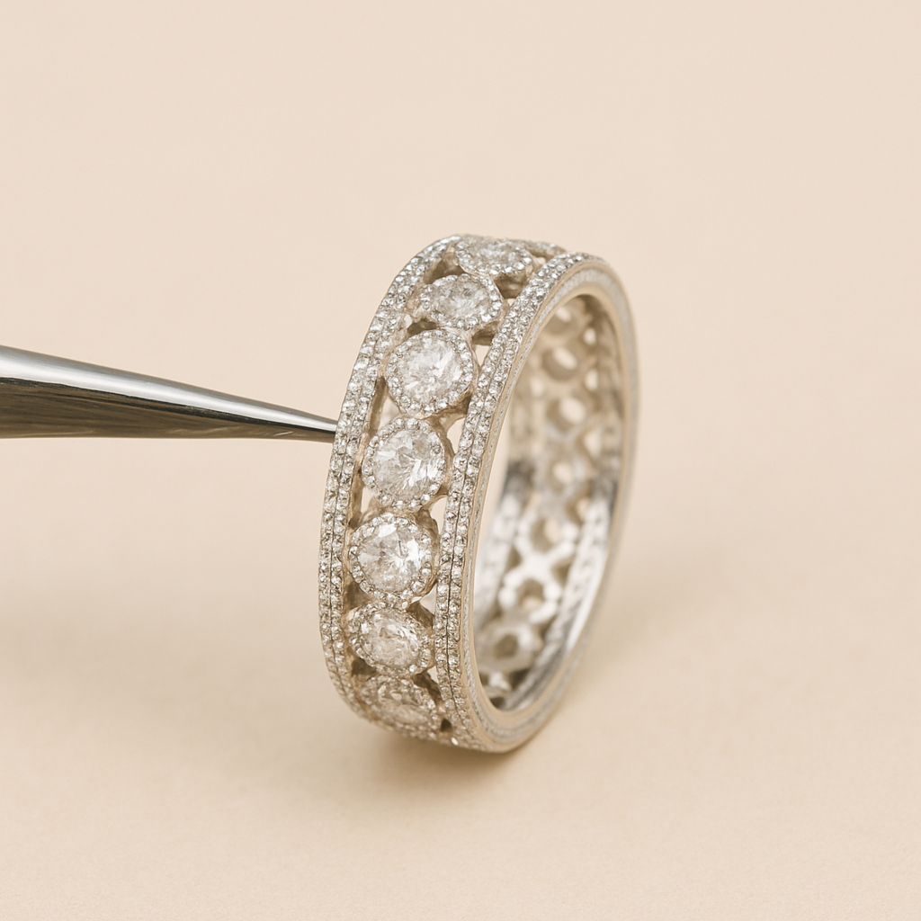 Elegant silver eternity band ring with large round-cut diamonds set in a row, held by tweezers against a soft beige background.