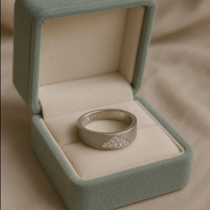Sterling silver men’s ring with geometric stone accent, displayed in a green velvet jewelry box.