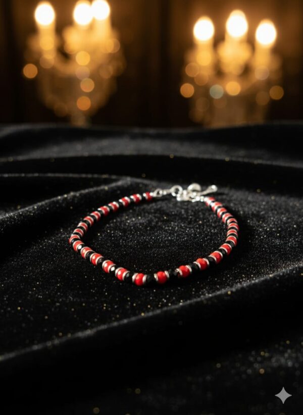 Handcrafted red, black, and white beaded bracelet worn on wrist in natural sunlight, with coffee and book in background — minimalist unisex accessory for protection and style.