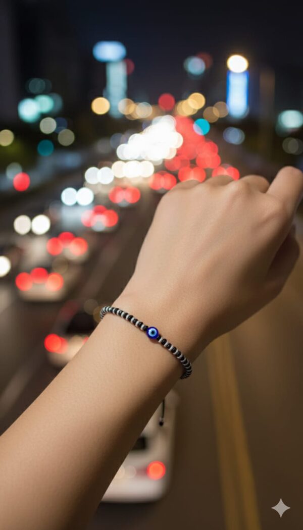 Black beaded bracelet with a central blue evil eye charm, laid on a black velvet background — minimalist unisex accessory symbolizing spiritual protection and grounding.