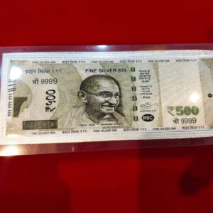 Pure 999 fine silver replica of Indian ₹500 currency note featuring Mahatma Gandhi, encased in a transparent acrylic cover and placed on red background — luxury gifting item.