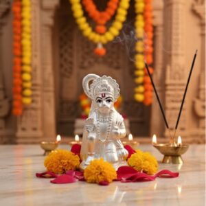 925 silver Hanuman Ji idol placed on a wooden pedestal with diyas and marigold garland in the background.